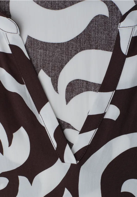 Close-up van een kledingstuk met een abstract zwart-wit patroon