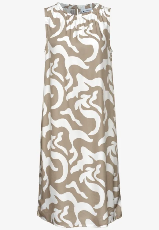 Mouwloze midilengte A-lijnjurk in beige met een wit, abstract patroon.