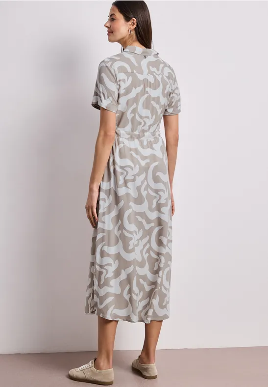 Frau von hinten in Midi-Kleid mit beigem abstraktem Muster, kurzen Ärmeln und hohem Ausschnitt