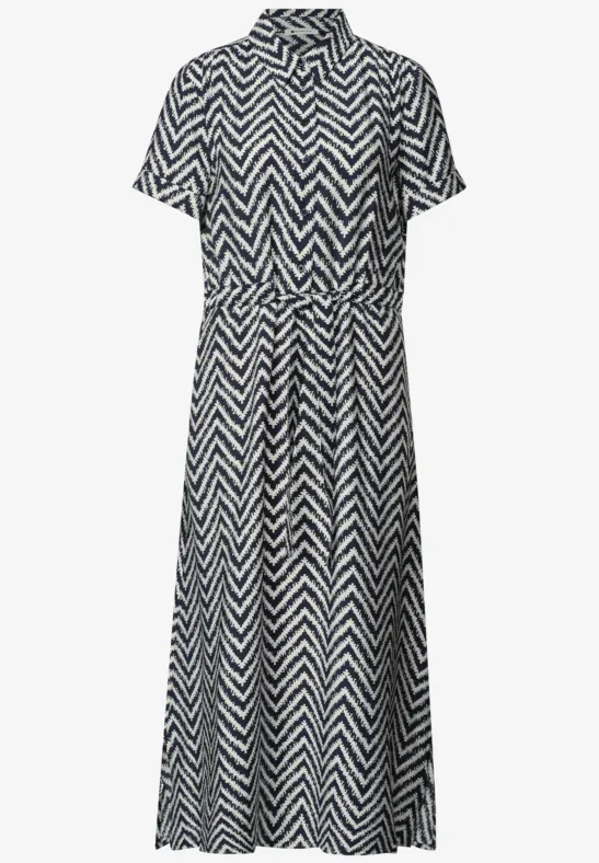Zwart-witte midi blousejurk met zigzagpatroon, overhemdkraag, knoopsluiting en tailleriem.
