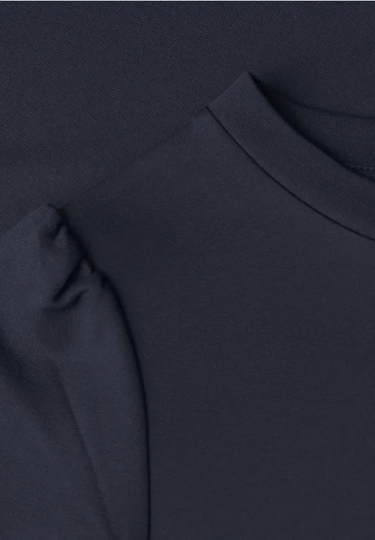 Close-up van een zwart kledingstuk met fijne textuur en ronde hals