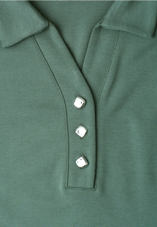 Polo vert avec col et trois boutons blancs de forme carrée.