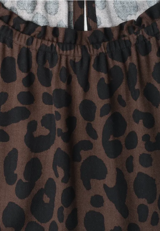 Bruine stof met onregelmatige zwarte vlekken, in luipaardprint.