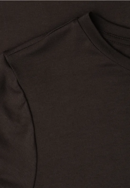 Close-up van een donkerbruin T-shirt met zichtbare halslijn, mouwinzet en stikselstructuur.