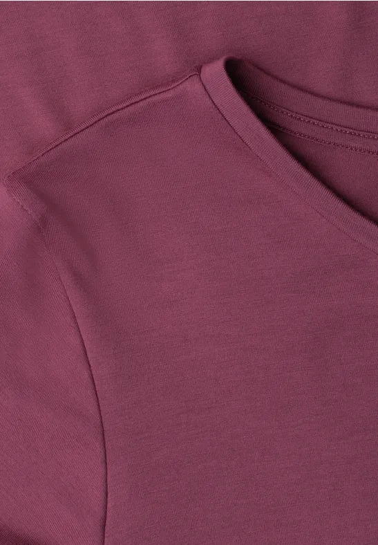 Close-up van een bordeauxrood T-shirt van zachte stof met ronde hals.