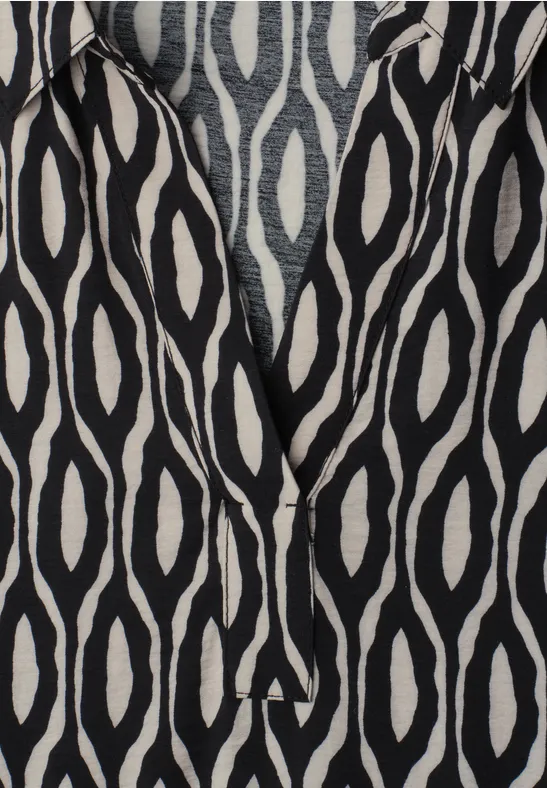 Tissu noir orné de motifs ovales blancs façon ikat.