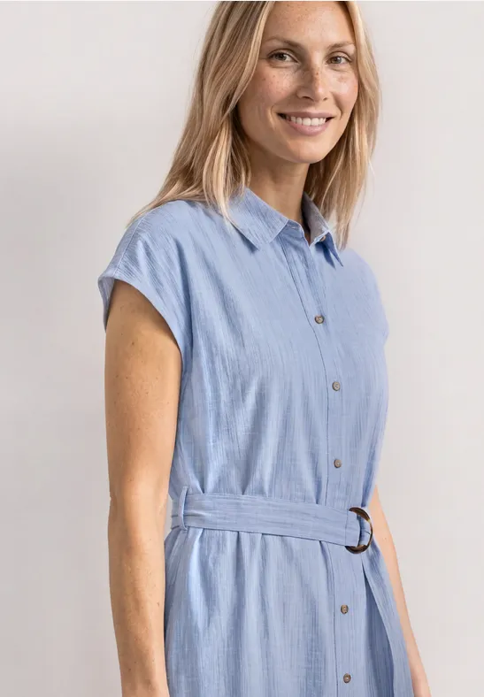 Eine Frau trägt ein hellblaues, kurzärmeliges Hemdkleid mit Taillengürtel.