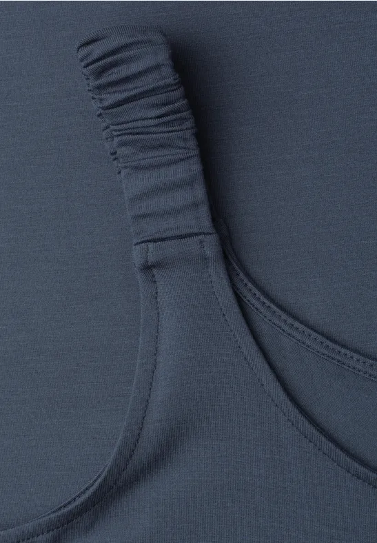 Close-up van een donkerblauwe bh-band met elastisch detail op textiel.