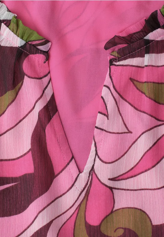 Top met roze bloemenprint, V-hals en plooien bij de schouders.