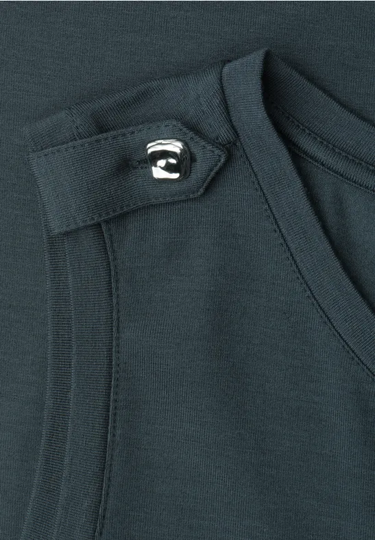 Gros plan d'un top sans manches en tissu sombre, avec patte d'épaule et détail de bouton.
