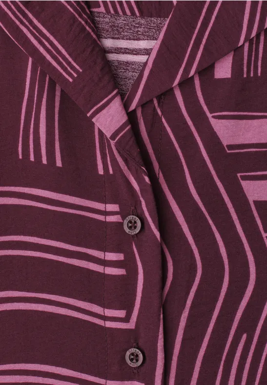 Close-up van een paarse blazer met grafische lijnen en twee zichtbare knopen.