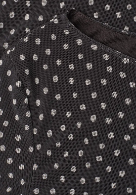 Haut noir à pois blancs avec encolure en V fendue