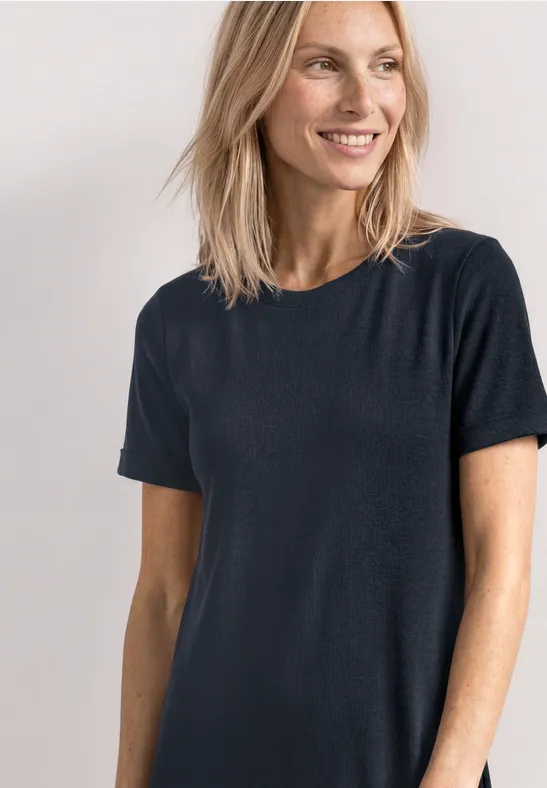 Vrouw met wazig gezicht draagt een eenvoudig, donker T-shirt voor een neutrale achtergrond.