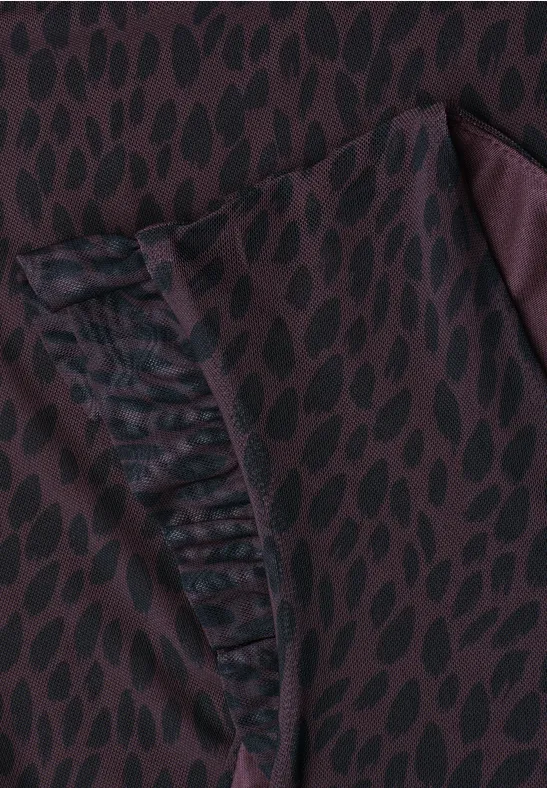 Close-up van bordeaux stof met zwart bladmotief en geplooide zak.