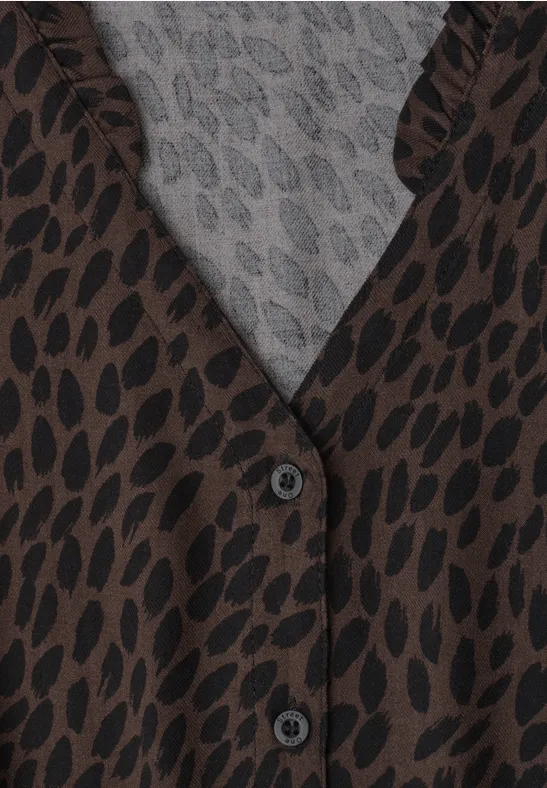 Braunes Langarmshirt mit schwarzem Leopardenmuster und grauer Innenseite, geknöpft.