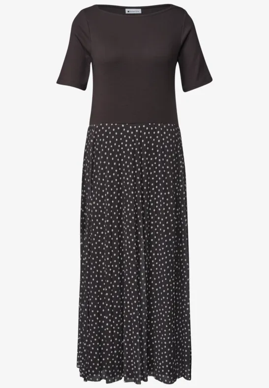 Robe noire à manches mi-longues et jupe fluide à pois blancs.