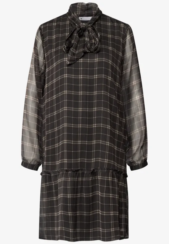 Robe noire à carreaux, manches longues, col noué et taille tombante pour un look décontracté.
