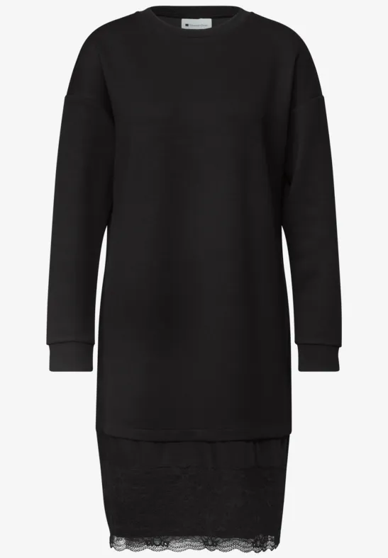 Robe pull noire à manches longues avec bord en dentelle discrète.
