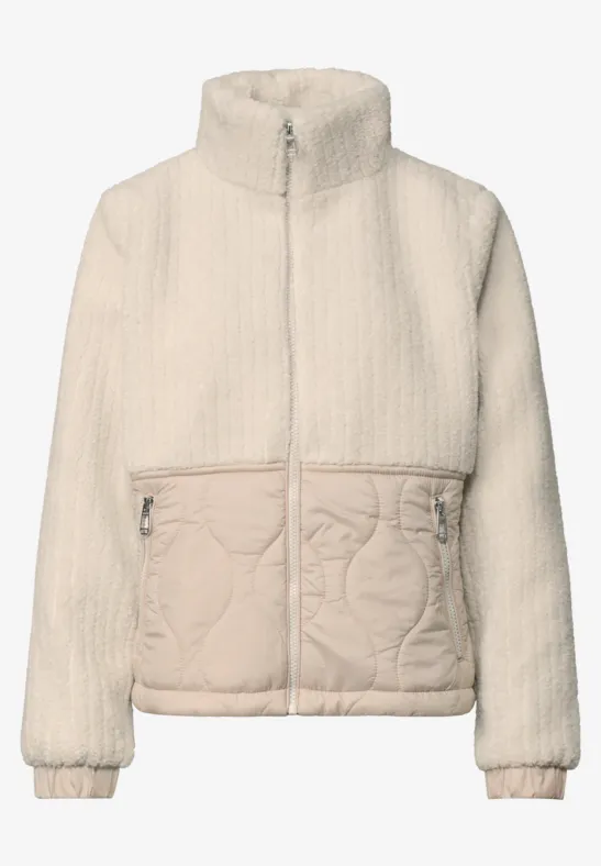 Veste en polaire beige style teddy, col montant, fermeture zippée intégrale et poches latérales.