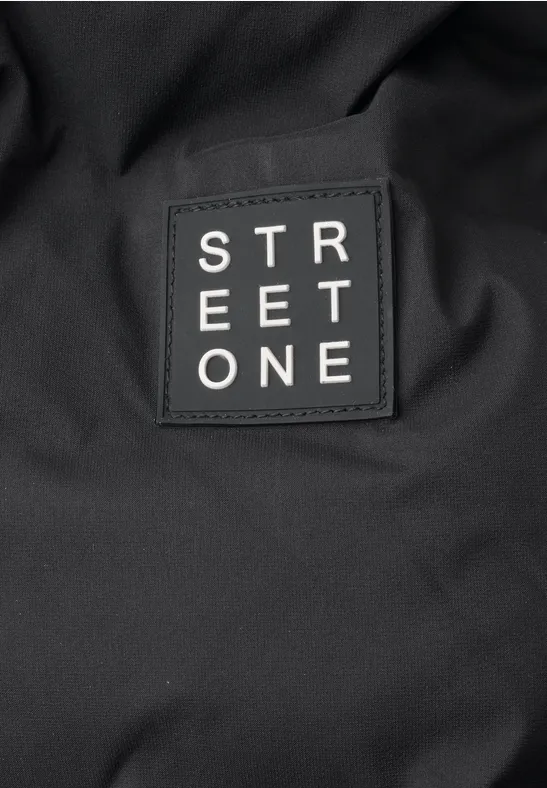 Gros plan sur un tissu noir orné d’un écusson 'STREET ONE' cousu.