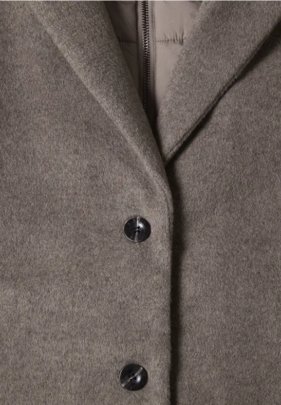 Close-up van een grijze wollen jas met revers en twee zwarte knopen
