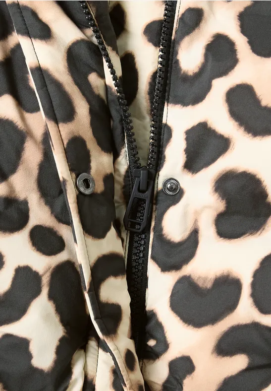 Nahaufnahme eines Reißverschlusses auf einem beige-schwarzen Leopardenmusterstoff.