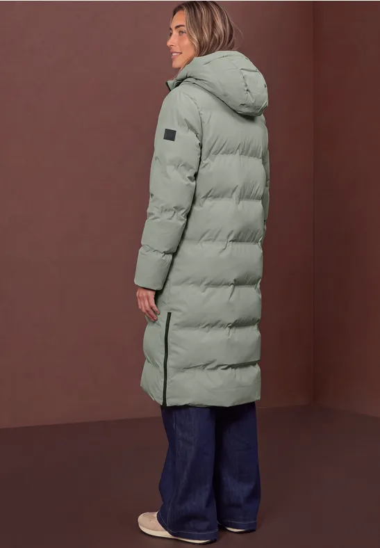 Seitliche Ansicht einer langen, grünen Pufferjacke mit Kapuze, Reißverschluss und seitlichen Schlitzen.
