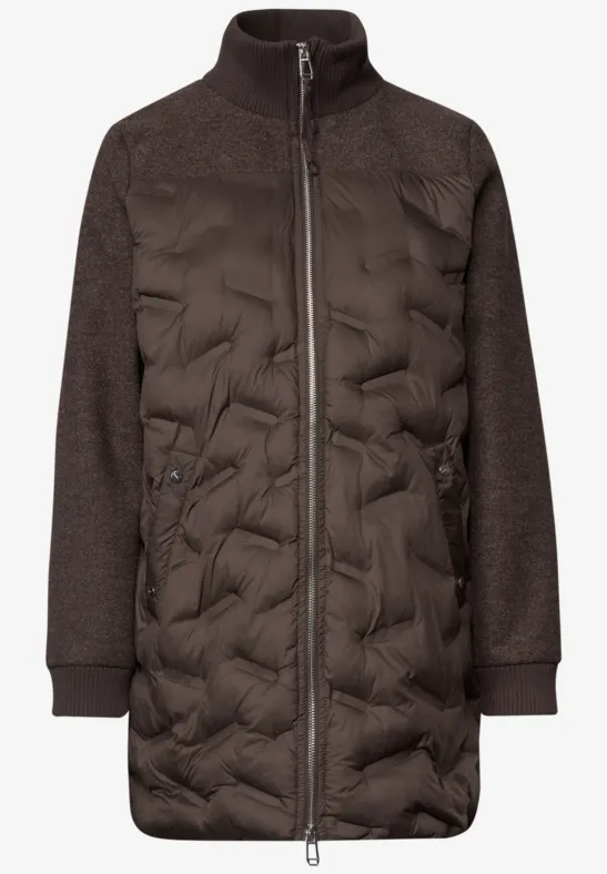 Manteau matelassé marron foncé, manches longues en maille, col montant et fermeture éclair intégrale.
