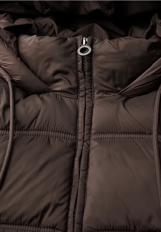 Nahaufnahme einer braunen Steppjacke mit Reißverschluss und Kapuze.
