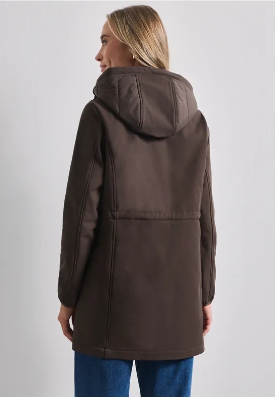 Femme de dos dans un manteau brun mi-long à capuche.