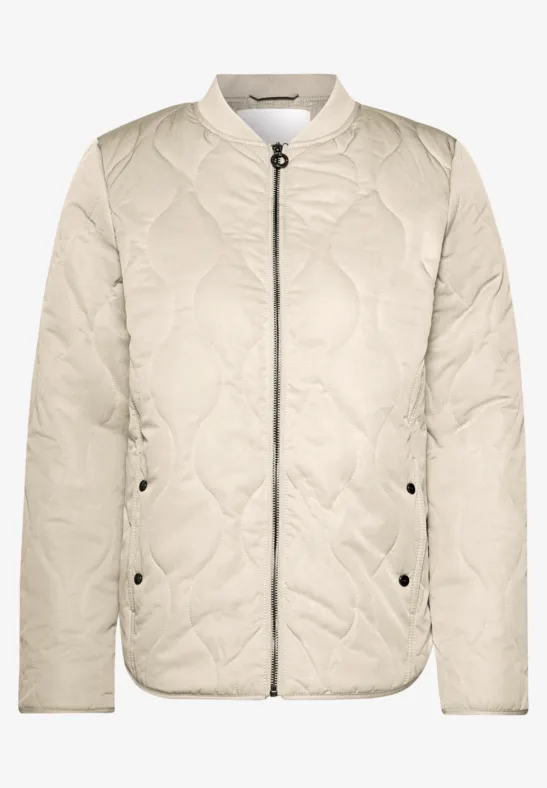 Veste bomber matelassée beige avec fermeture éclair, col montant et poches latérales.