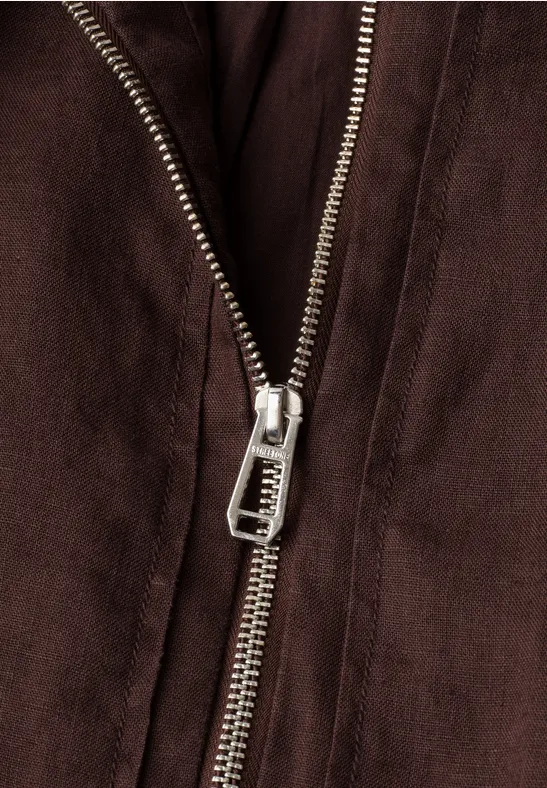 Nahaufnahme eines Metallreißverschlusses an einer braunen Jacke.