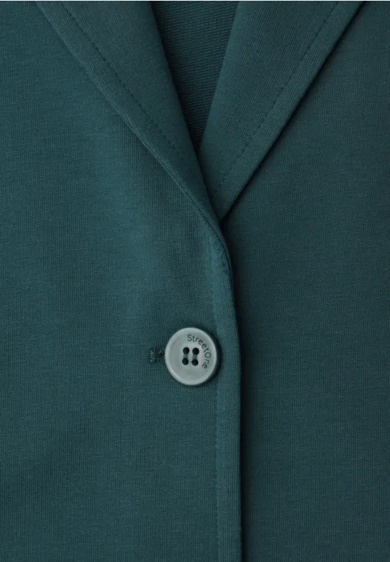 Close-up van een donkergroene jas met reverskraag en een knoop in het midden.