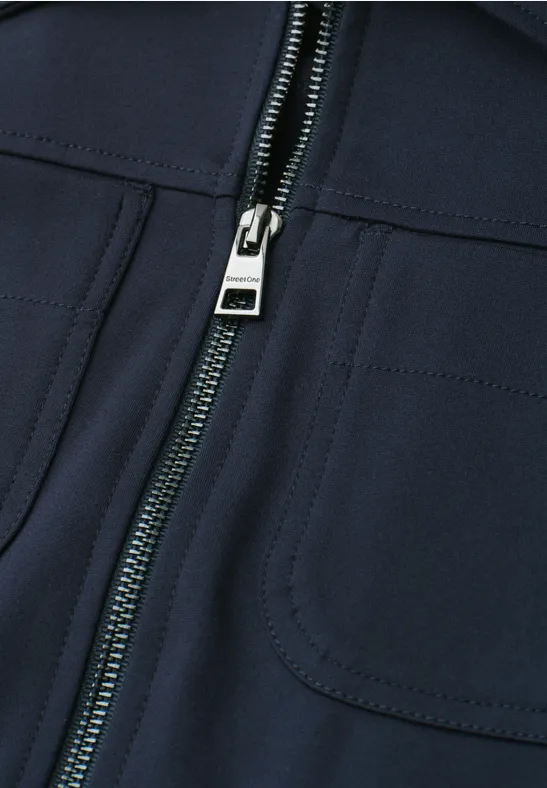 Nahaufnahme einer dunkelblauen Jacke mit Reißverschluss und aufgesetzten Taschen.