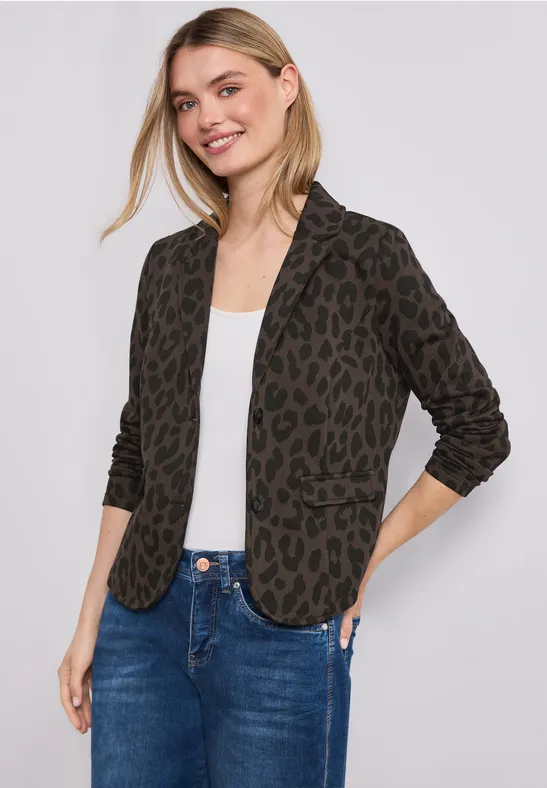 Femme portant un blazer léopard, un t-shirt blanc et un jean.
