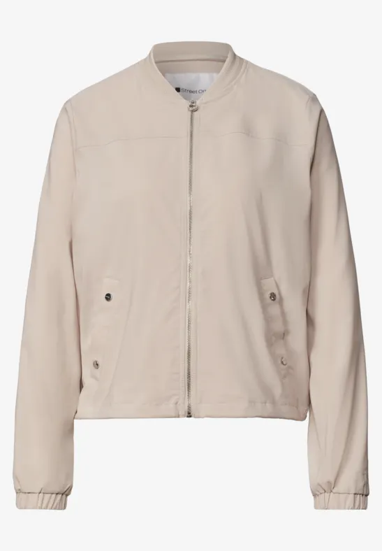 Blouson bomber beige clair avec fermeture éclair, poches latérales et manches longues.