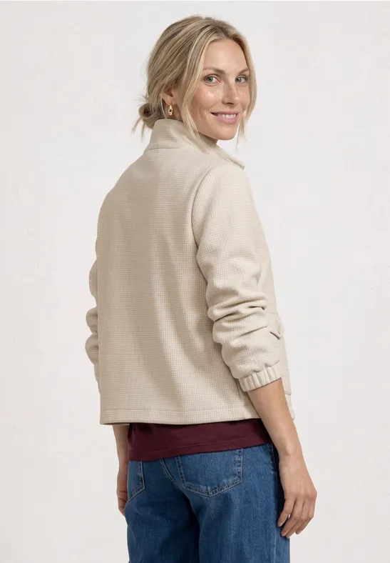 Vue de dos d'une personne en veste polaire beige et jean.