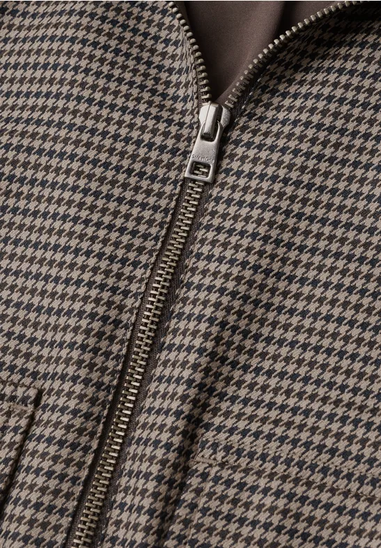 Nahaufnahme eines braun-schwarzen Hahnentritt-Musters mit Reißverschluss