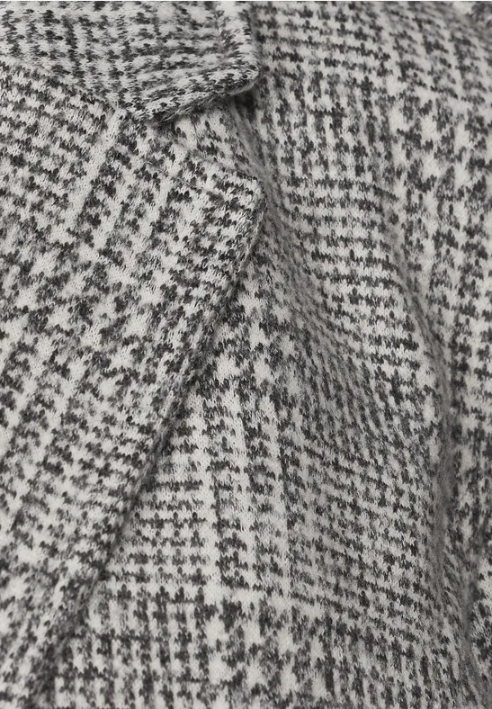 Gros plan d’un tissu en laine à motif pied-de-poule noir et blanc.