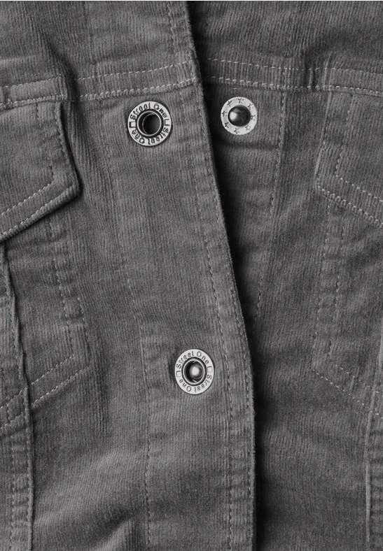 Detailansicht einer Jacke mit Druckknöpfen auf dunkelgrauem Stoff