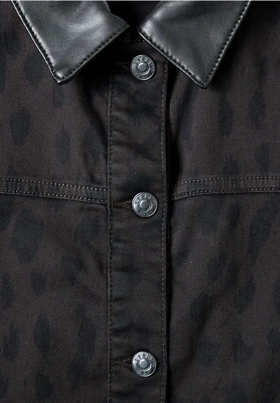 Veste noire à motif léopard discret, col en cuir brillant et boutons sur le devant.