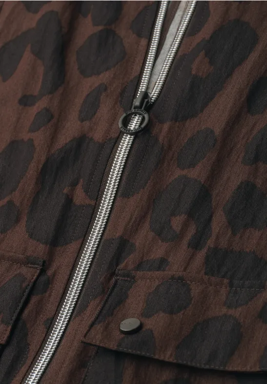 Veste marron à motif léopard noir, fermeture éclair centrale avec tirette en anneau.