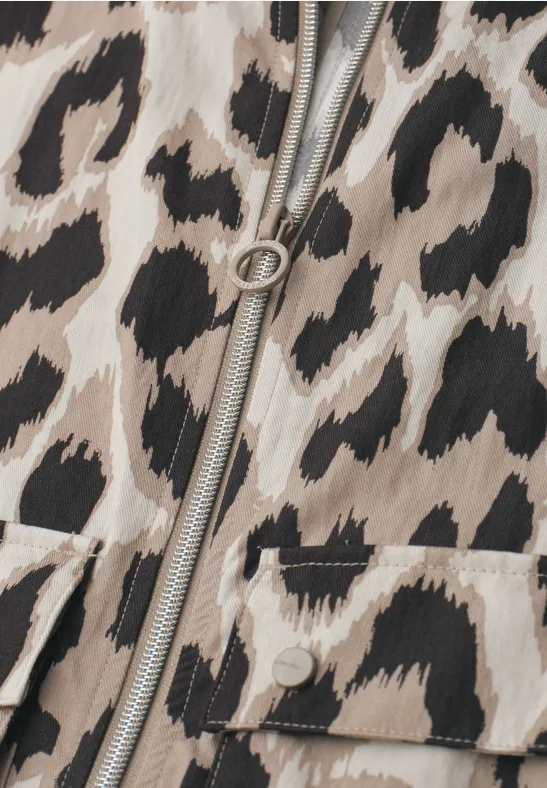Gros plan sur une fermeture éclair et une poche sur tissu à motif léopard beige et marron.