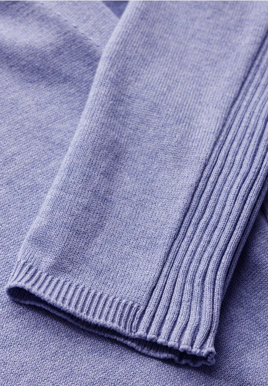 Nahaufnahme eines lilafarbenen, gestrickten Pullovers.