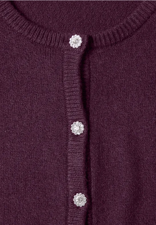 Close-up van een paars gebreid vest met glanzende zilveren knopen
