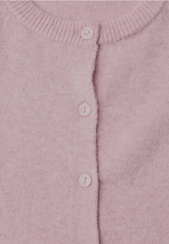 Close-up van een roze gebreid vest met knopen.