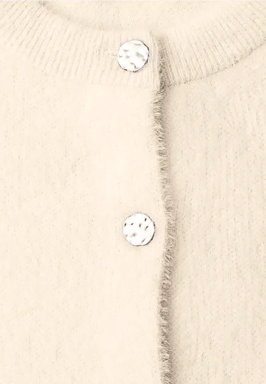 Beige, zachte gebreide cardigan met subtiele franjes en twee grote marmer-look knopen.