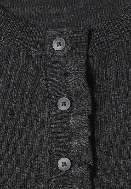 Gros plan sur un gilet noir en maille à trois boutons et bord côtelé.