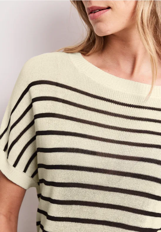 Nahaufnahme einer Frau im cremefarbenen Shirt mit schwarzen Querstreifen und kurzem Ärmel.