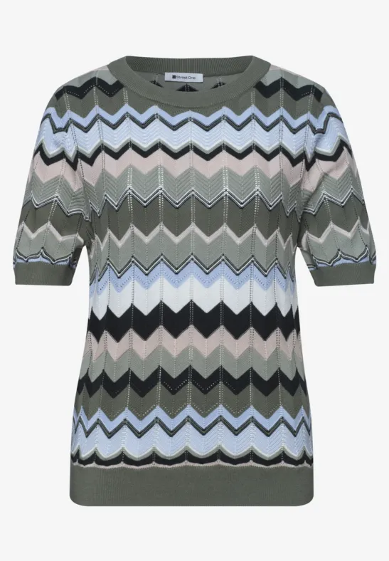 Kort gebreid topje met zigzagpatroon in groen, blauw, zwart en wit.